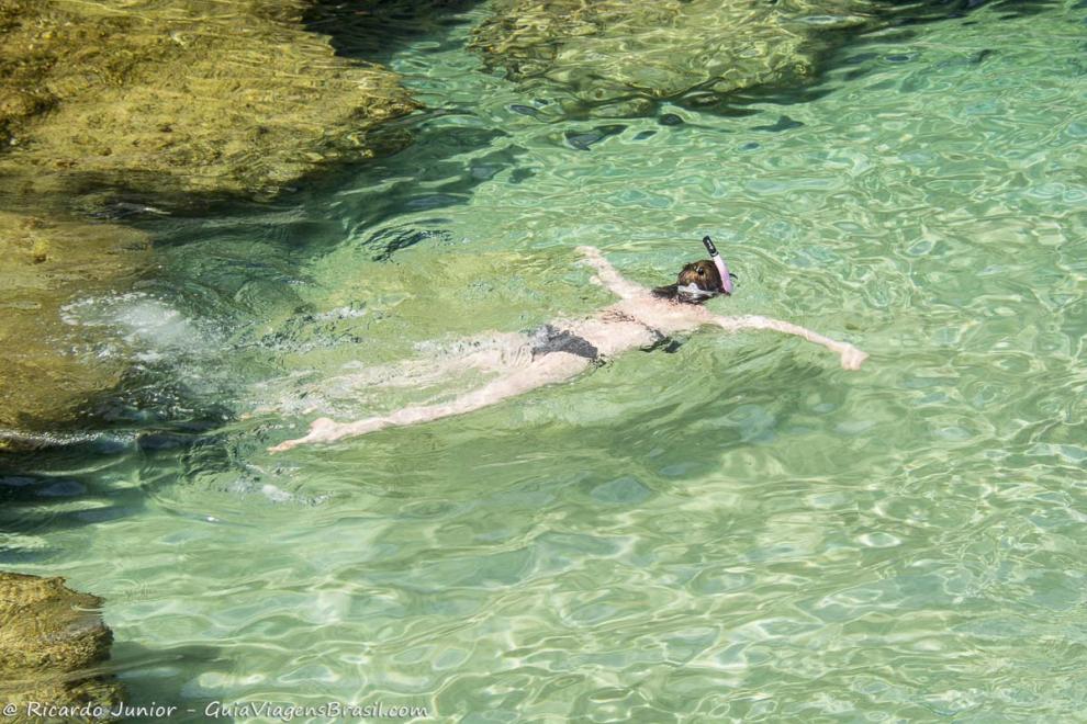 Imagem de uma moça mergulhando nas águas claras de Fernando de Noronha.